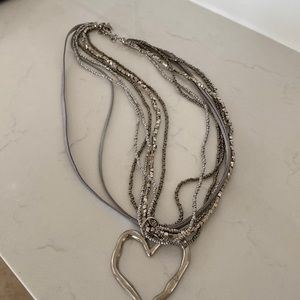 Necklace shown with black dress. Silver with heart